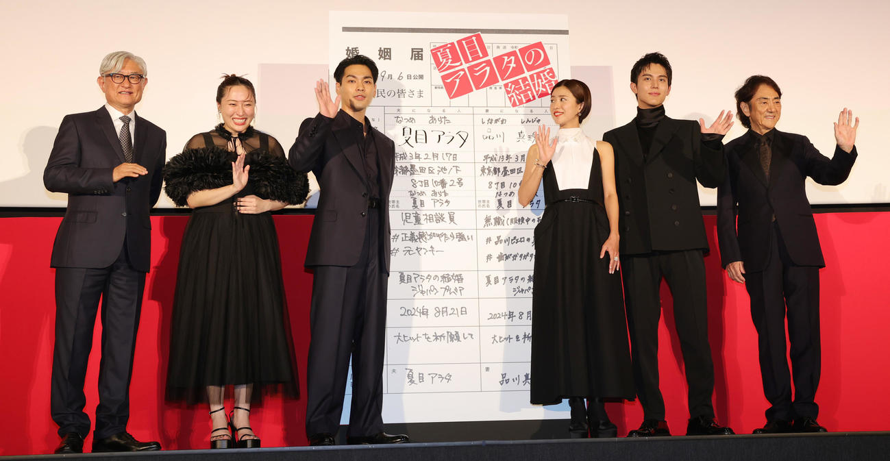 映画「夏目アラタの結婚」ジャパンプレミアに登場した、左から堤幸彦監督、丸山礼、柳楽優弥、黒島結菜、中川大志、市村正親。柳楽優弥と黒島結菜は、ヒット祈願のため婚姻届型パネルに署名（撮影・野上伸悟）