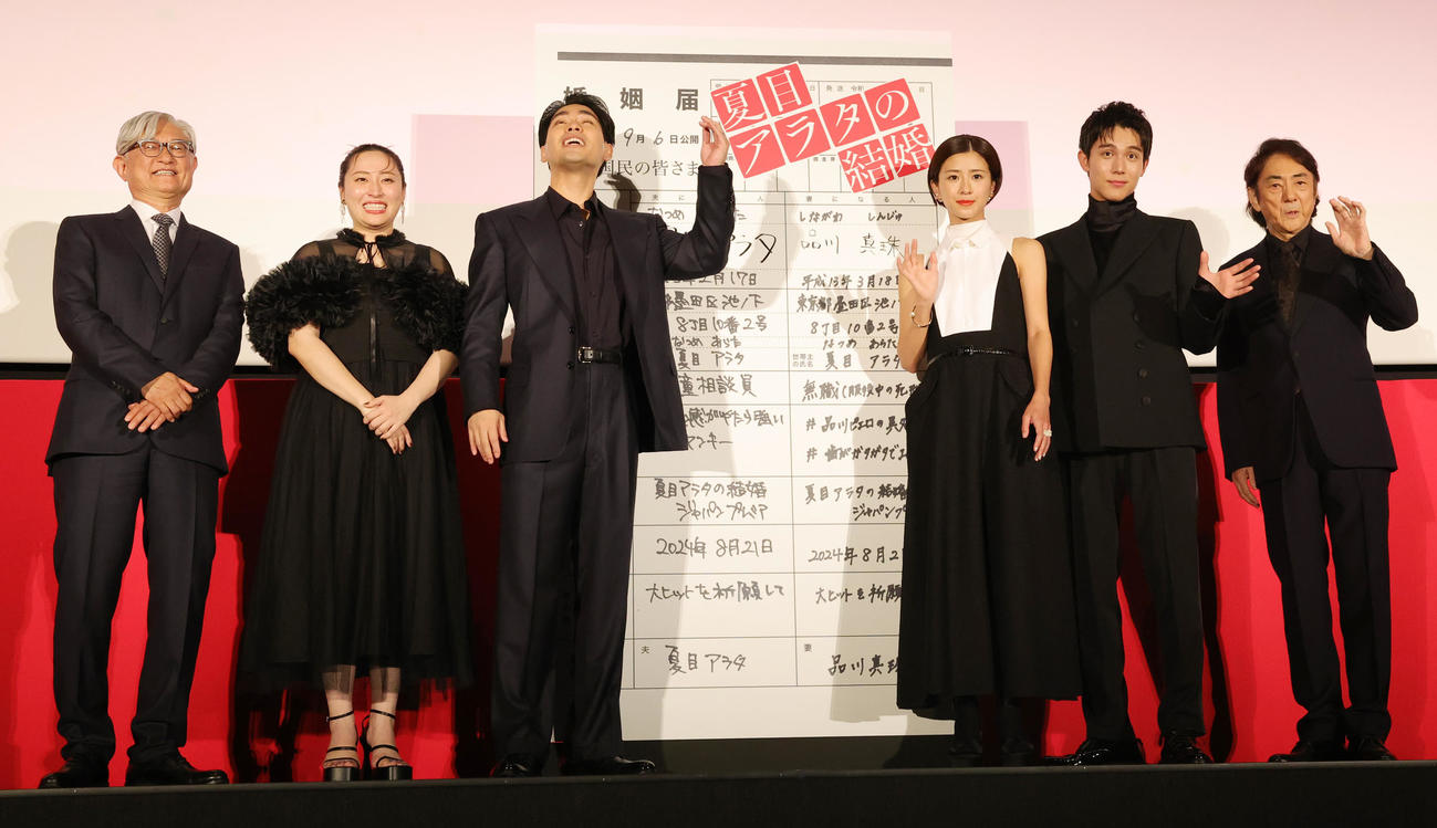 映画「夏目アラタの結婚」ジャパンプレミアに登場した、左から堤幸彦監督、丸山礼、柳楽優弥、黒島結菜、中川大志、市村正親。柳楽優弥と黒島結菜は、ヒット祈願のため婚姻届型パネルに署名（撮影・野上伸悟）
