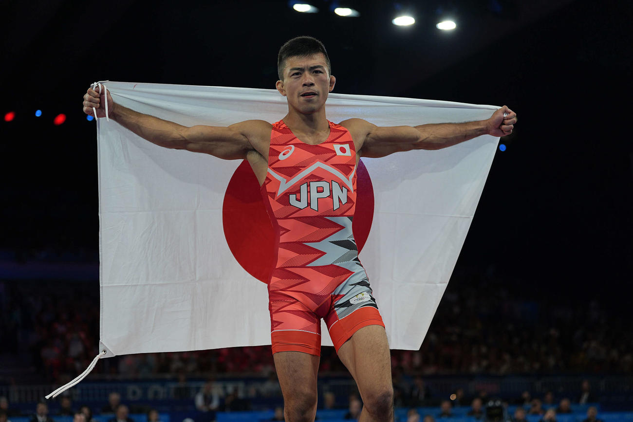 レスリング男子グレコローマンスタイル60キロ級決勝　中国の曹利国を破り、日の丸を手にポーズを決める文田（2024年8月6日撮影・パオロ　ヌッチ）