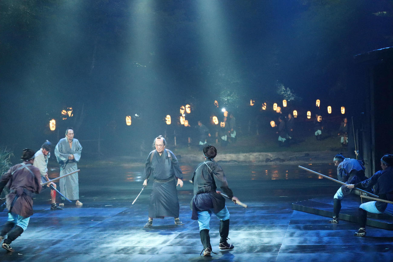 舞台奥が開く能登演劇堂で舞台「いのちぼうにふろう物語」主演の仲代達矢（中央）は立ち回りを見せる（2022年撮影）