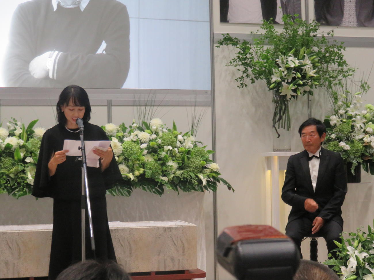 生前葬で東尾理子夫人（左）の読み上げる弔辞を聞く石田純一