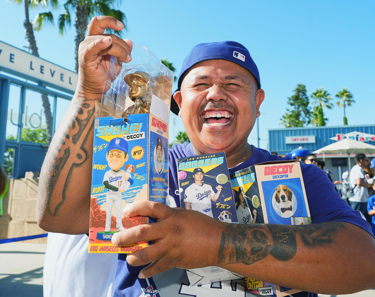 ドジャース対オリオールズ　ゴールドの大谷とデコピンのボブルヘッド人形をゲットし、笑顔を見せるファン（撮影・菅敏）