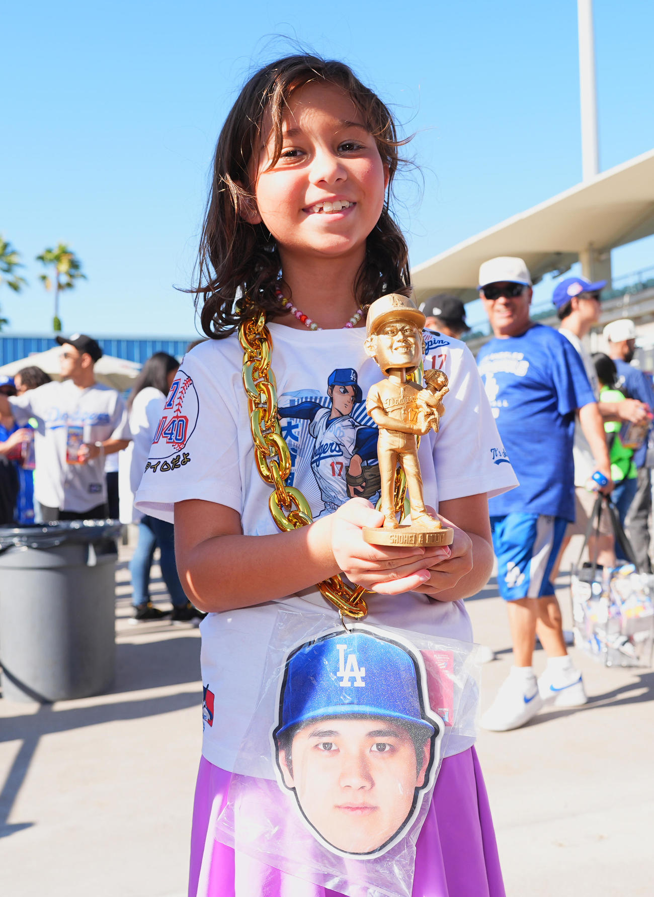 ドジャース対オリオールズ　ゴールドの大谷とデコピンのボブルヘッド人形をゲットし、笑顔を見せるファン（撮影・菅敏）