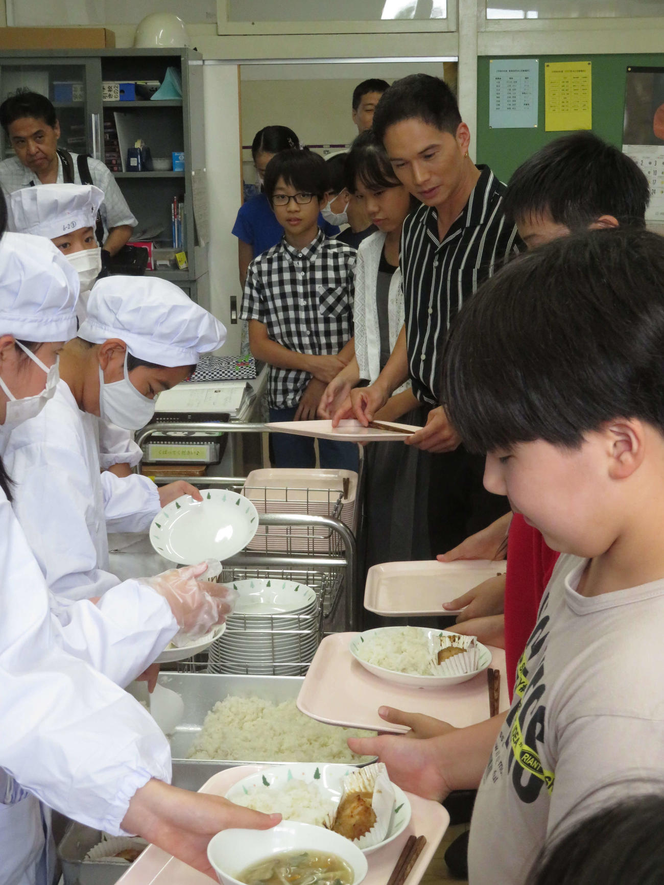 「おいしい給食コンテスト」で、TOKYO MX特別賞を受賞した東京・杉並区立杉並第一小学校を訪問し、6年2組で給食を求め、列に並ぶ市原隼人（中央）（撮影・村上幸将）