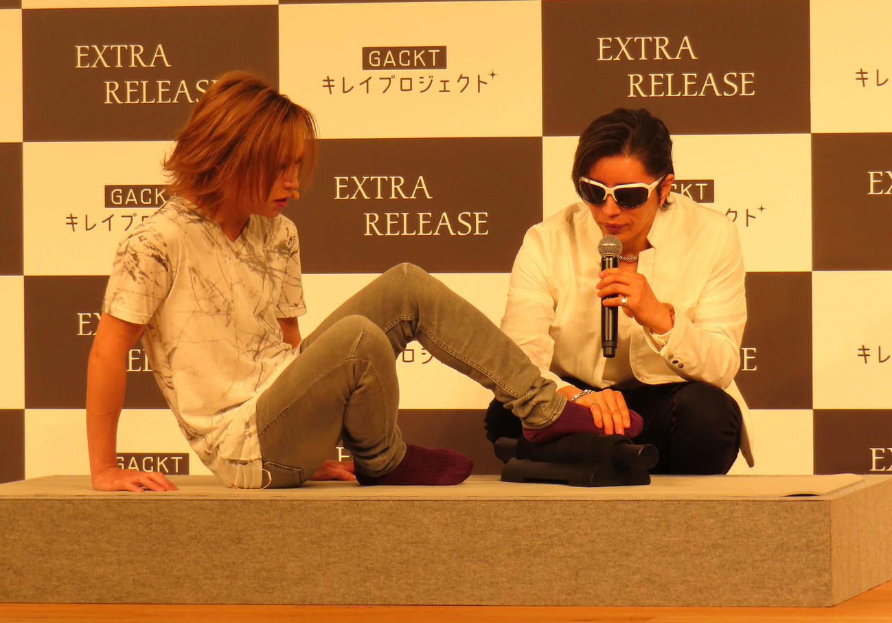 ストレッチローラーを体験するゴールデンボンバー鬼龍院翔（左）とレクチャーするGACKT