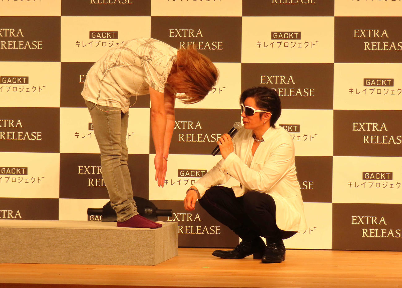 ストレッチローラー体験前に前屈するゴールデンボンバー鬼龍院翔（左）と見まもるGACKT