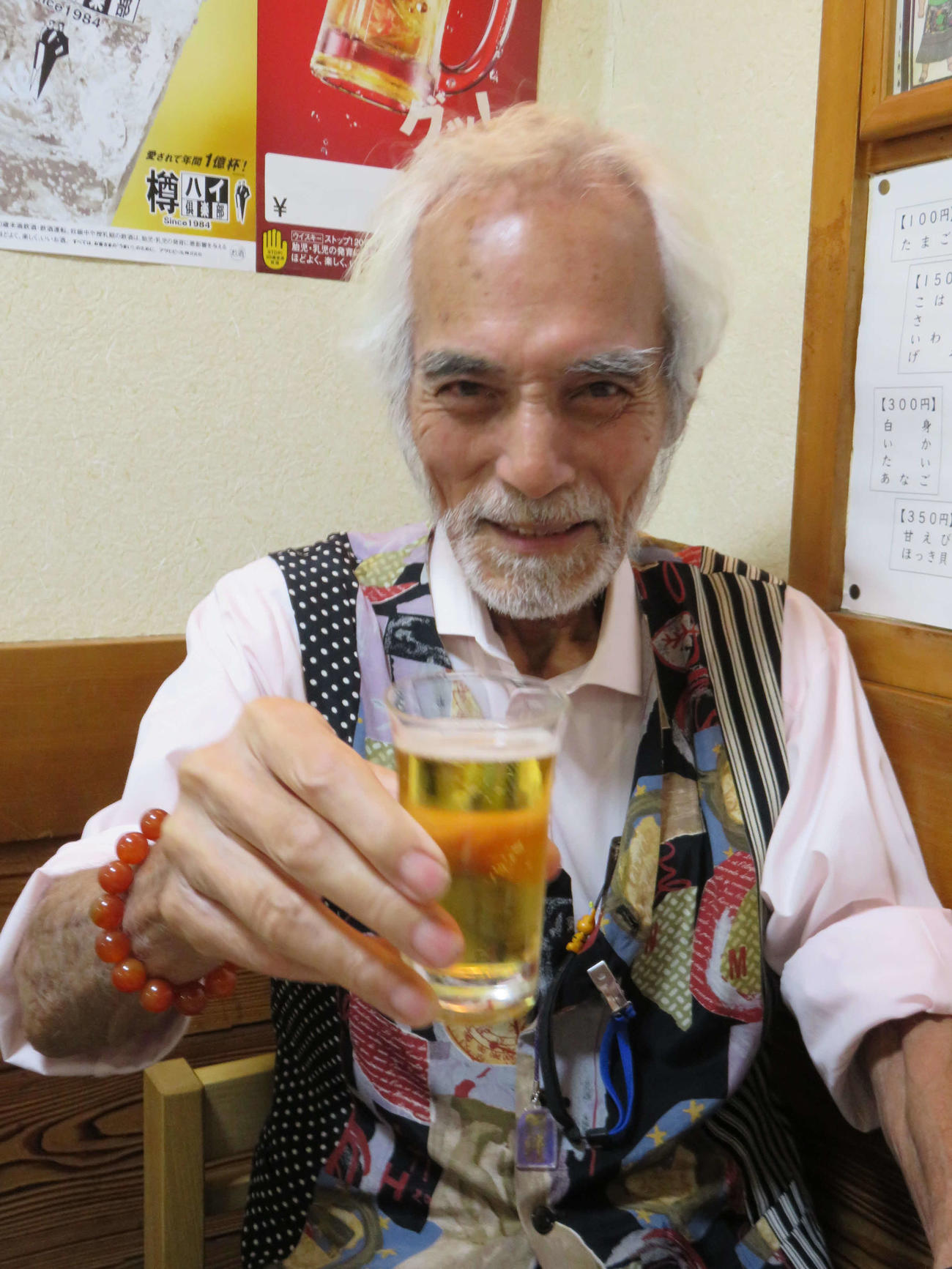 インタビューの合間に笑顔でビールのグラスを手にする堀田眞三