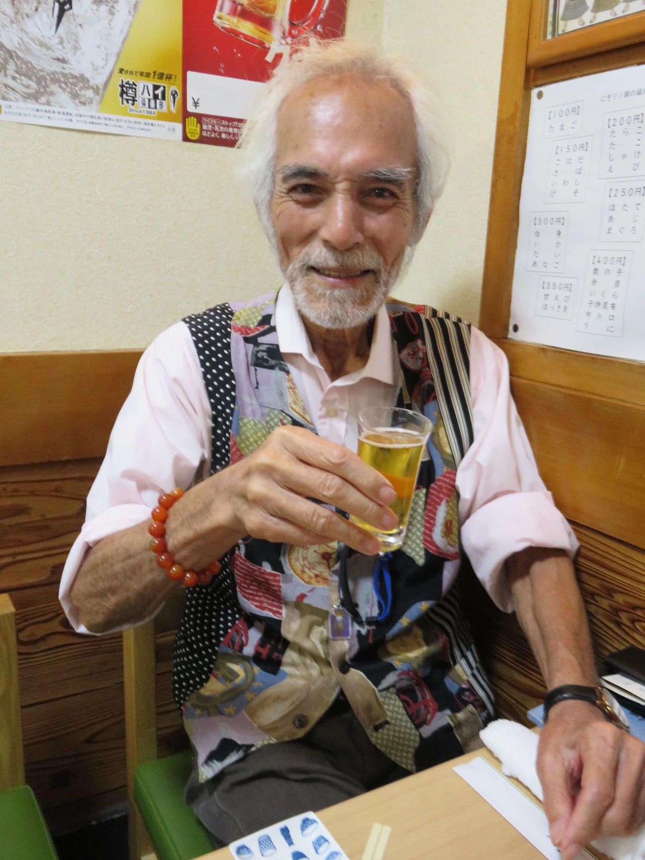 インタビューの合間に笑顔でビールのグラスを手にする堀田眞三