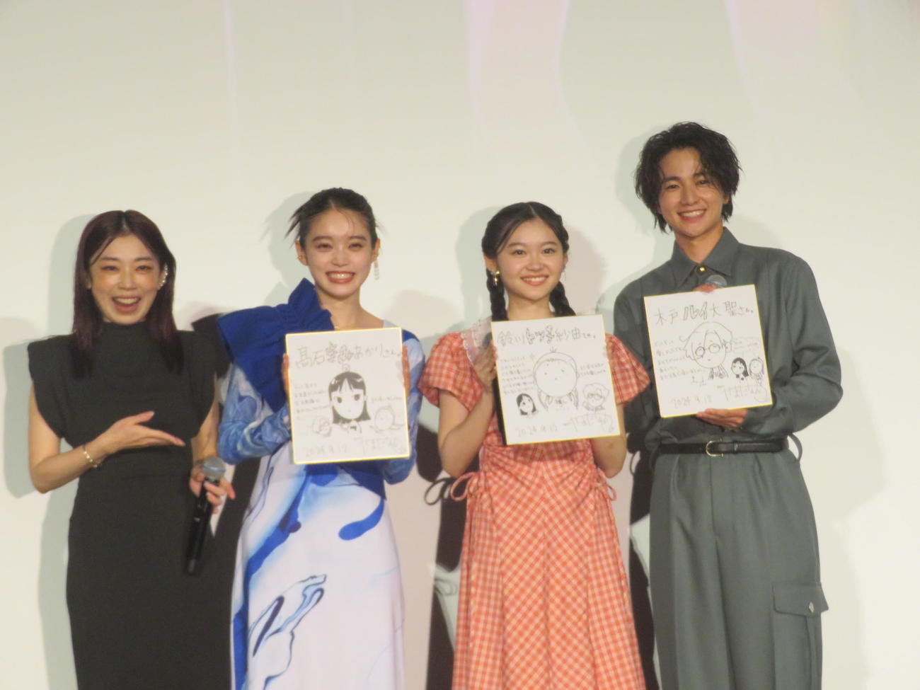 山田尚子監督（左）からの色紙を披露する高石あかり（中央左）、鈴川紗由（中央右）、木戸大聖（右）