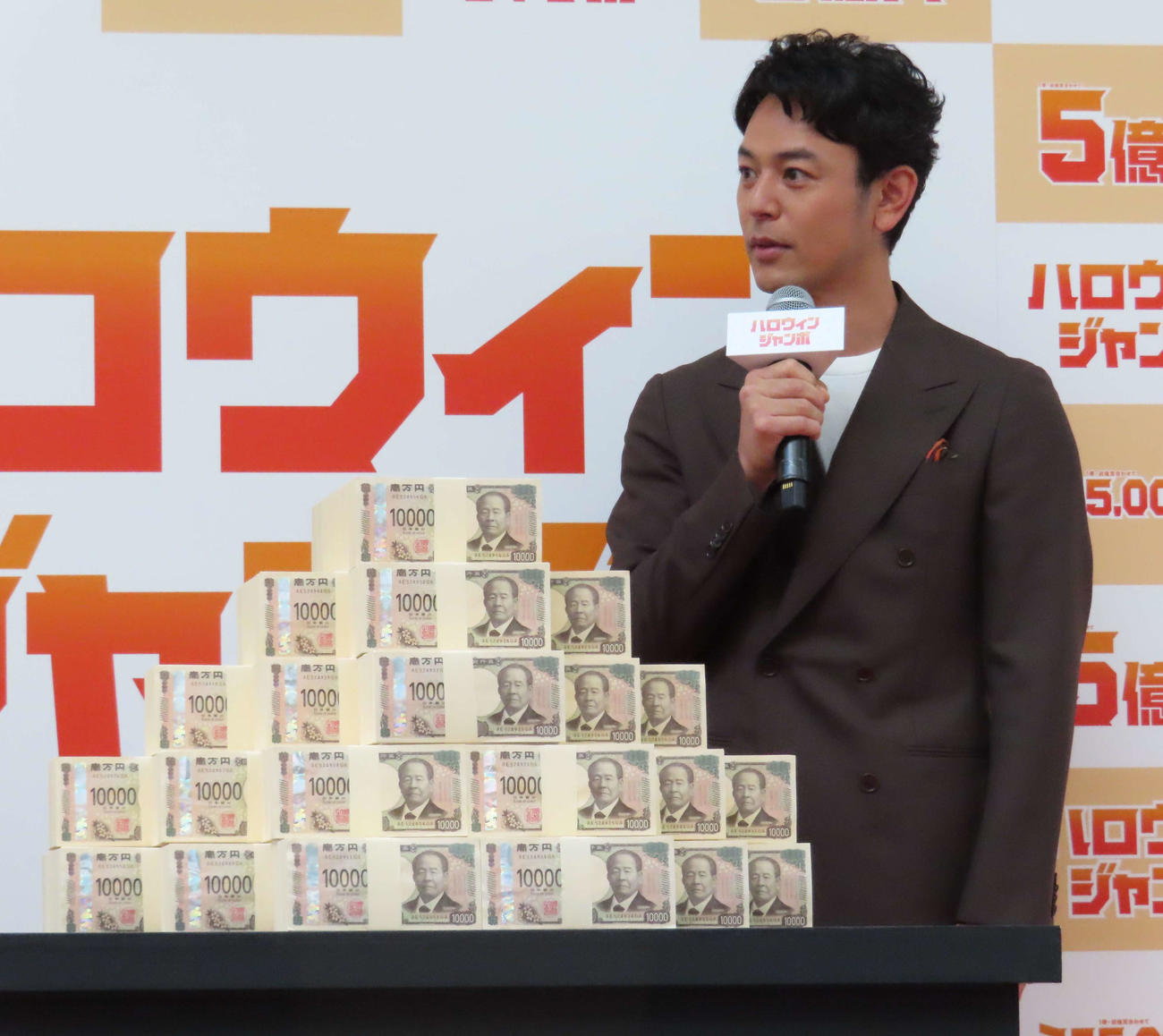 「ハロウィンジャンボ宝くじ」「ハロウィンジャンボミニ」発売記念イベントで、新紙幣の5億円と対面する妻夫木聡