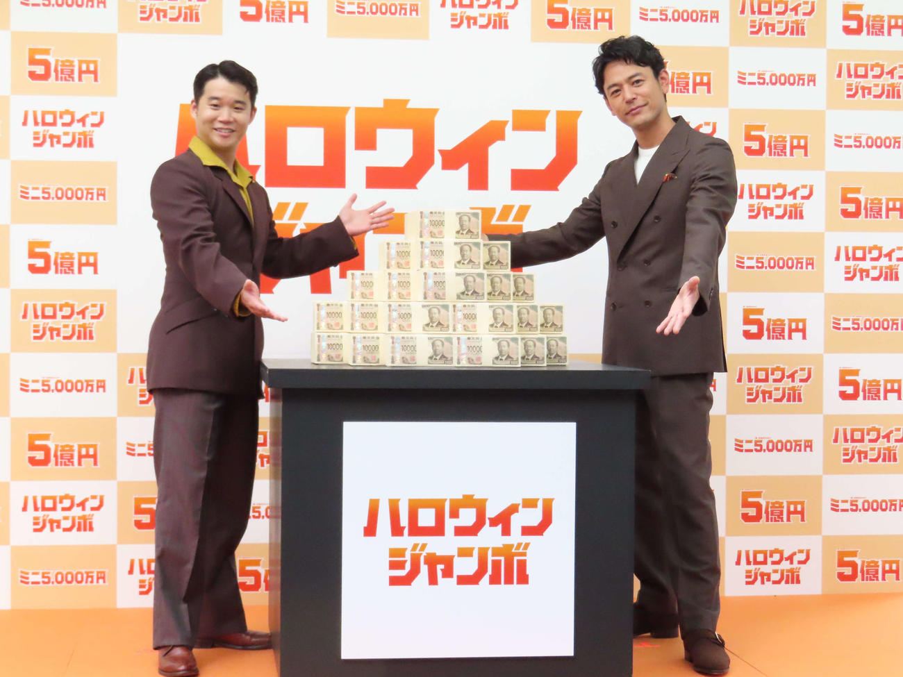 「ハロウィンジャンボ宝くじ」「ハロウィンジャンボミニ」発売記念イベントで、5億円を見せる矢本悠馬（左）と妻夫木聡
