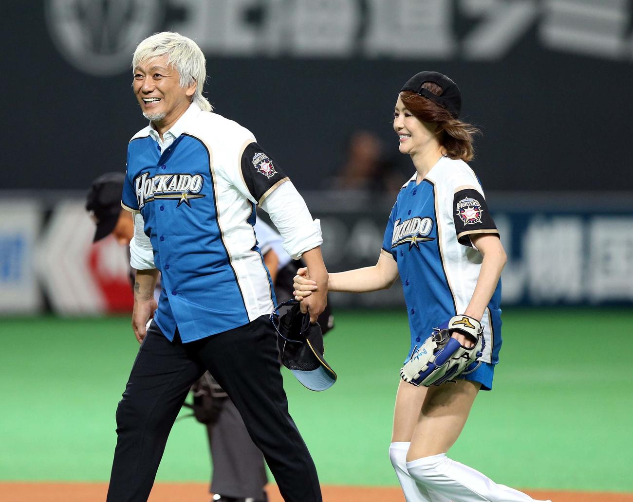 日本ハム－ソフトバンク戦で始球式を務めた青田典子と手をつなぐ玉置浩二（2014年撮影）