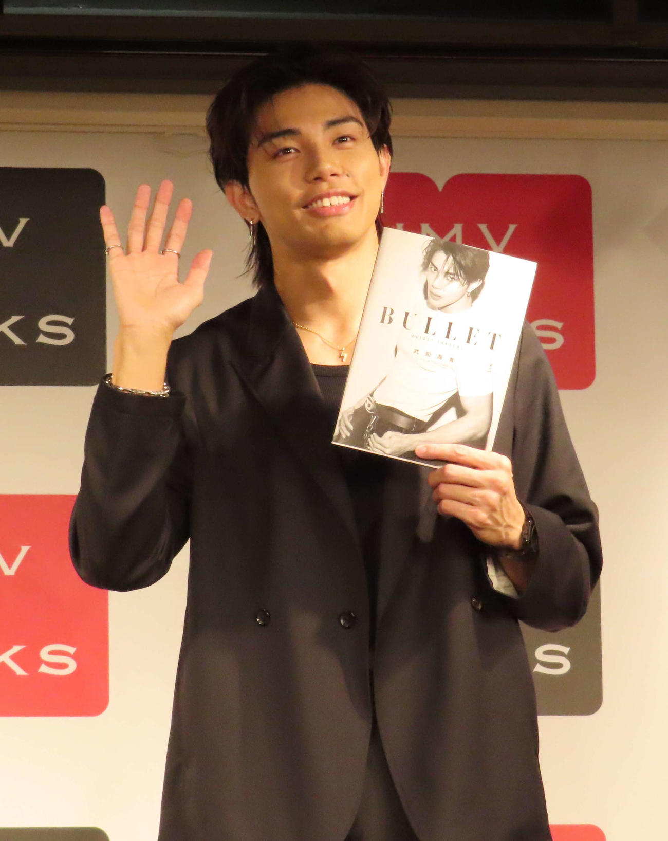 ボディ・ビジュアルブック「BULLET」刊行記念イベントで、写真集を手に笑顔を見せるTHE RAMPAGEの武知海青