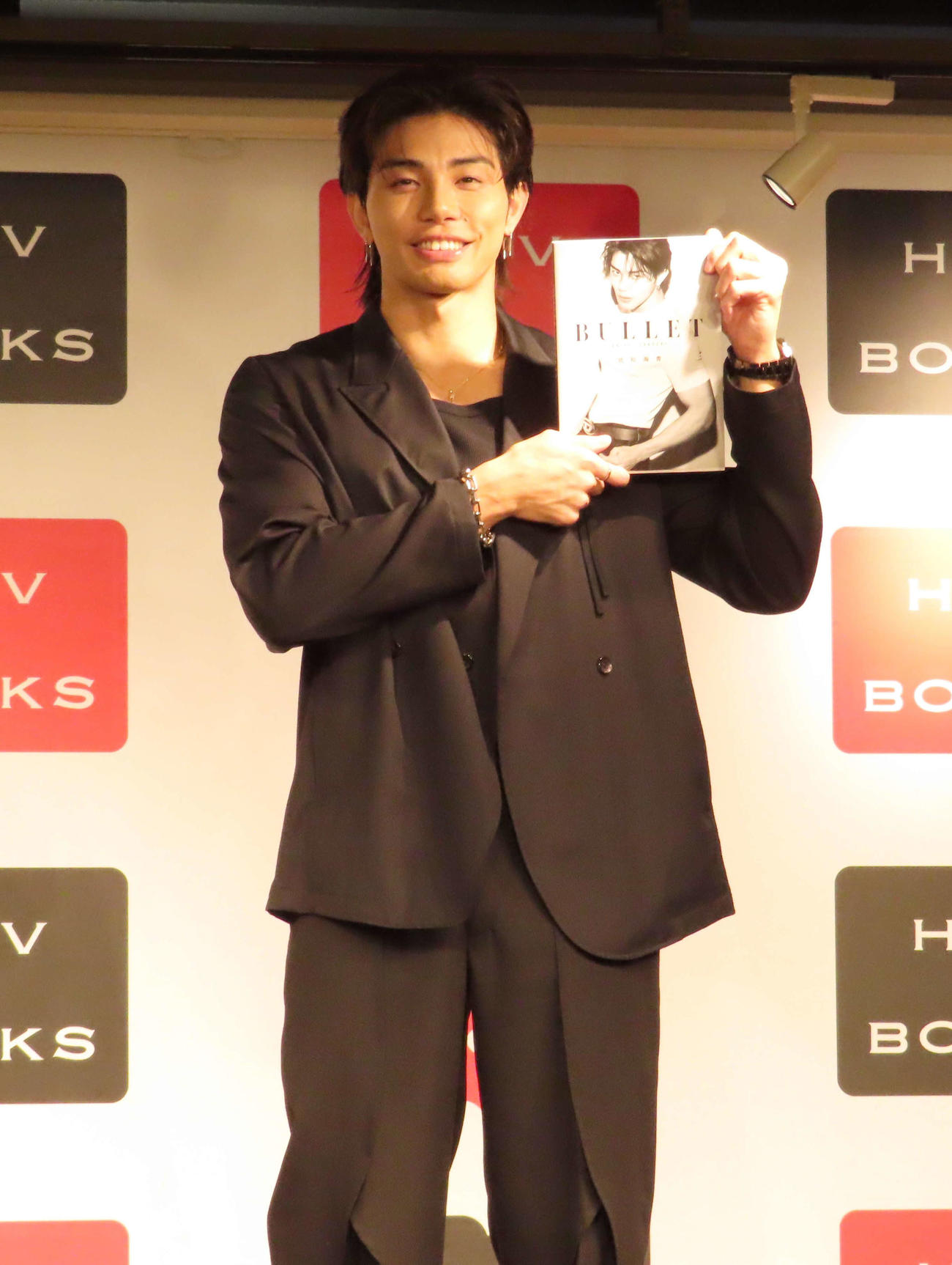 ボディ・ビジュアルブック「BULLET」刊行記念イベントで、写真集を手に笑顔を見せるTHE RAMPAGEの武知海青