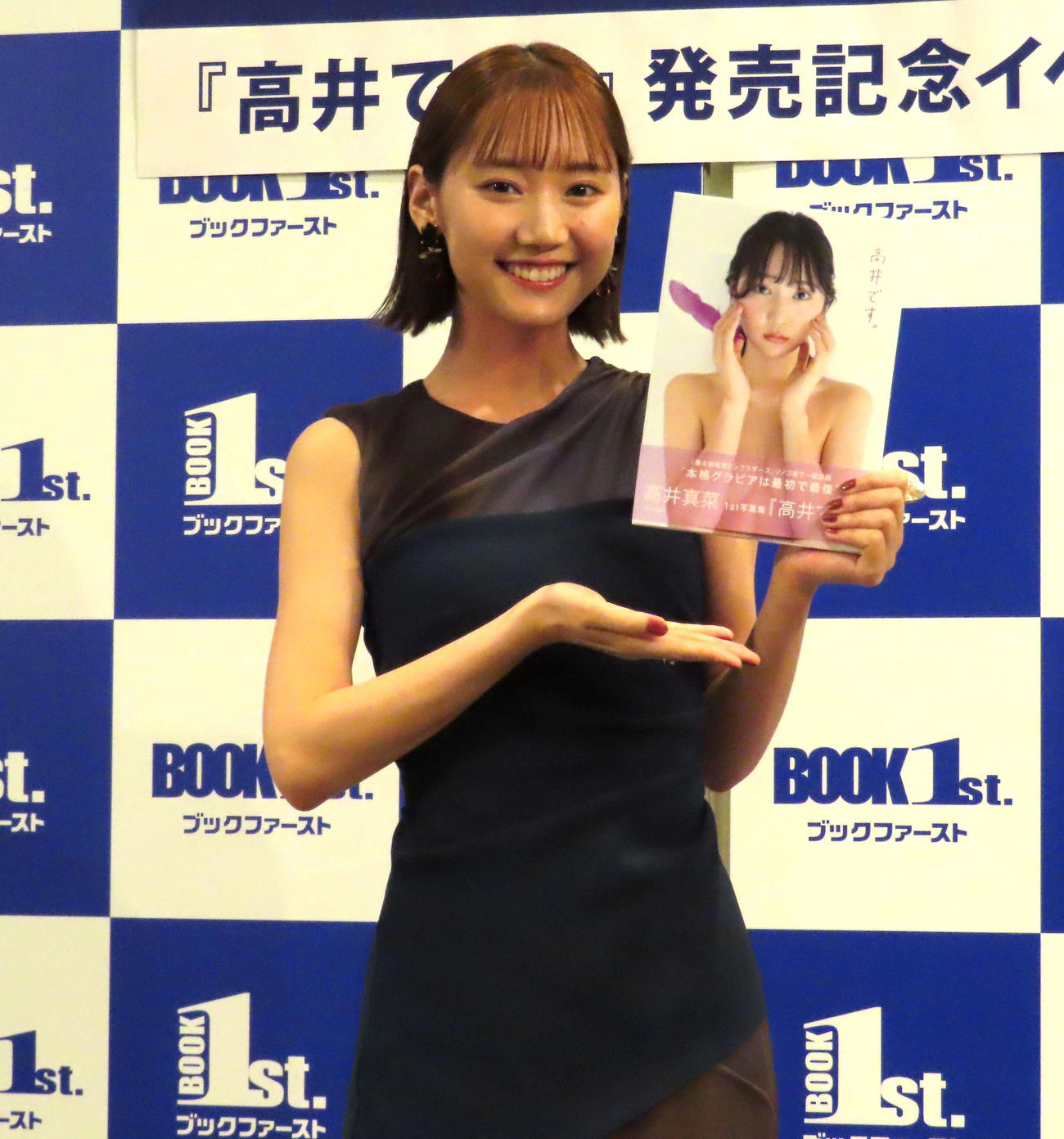 ファースト写真集「高井です。」発売記念イベントで、写真集を手に笑顔を見せる高井真菜