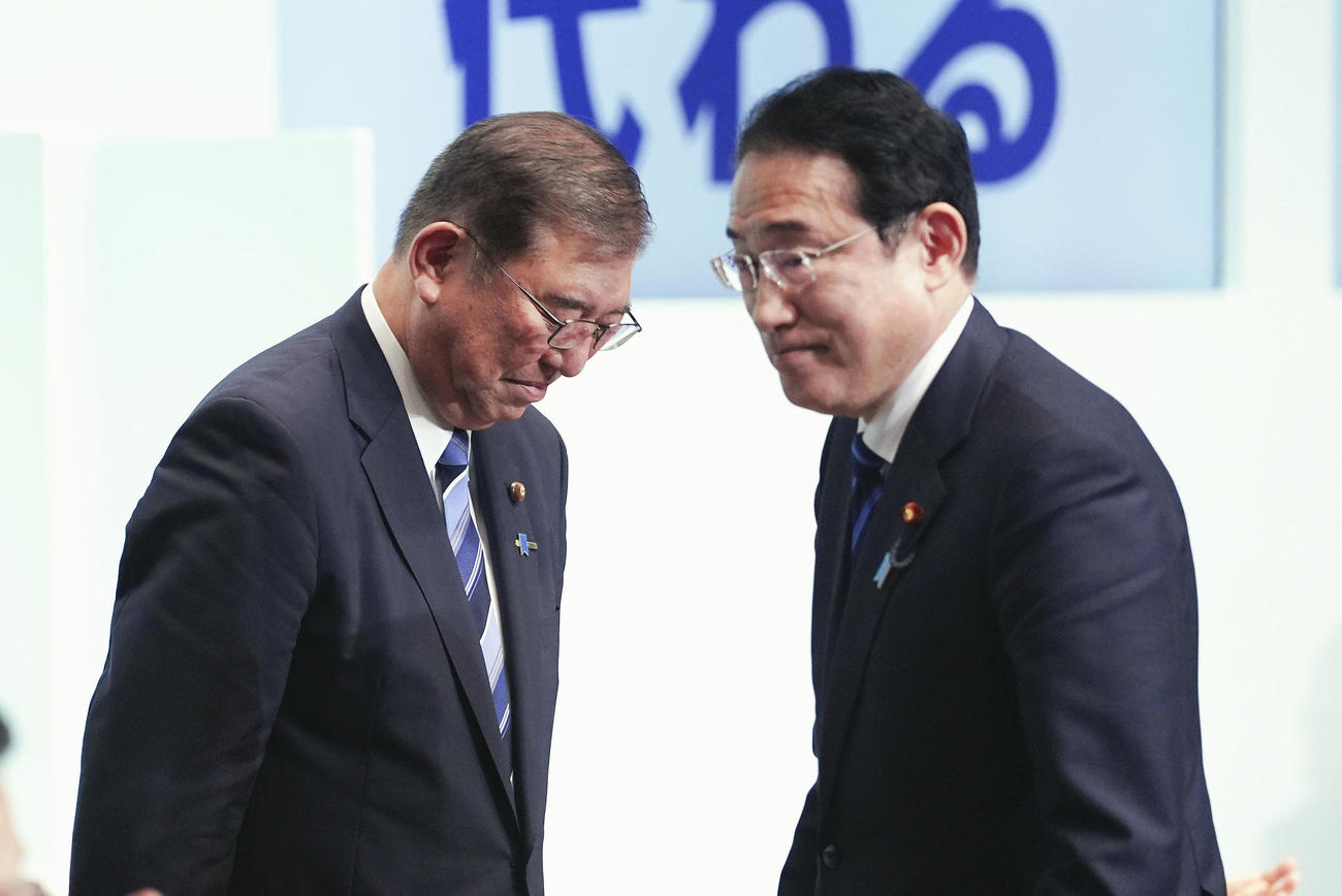 自民党総裁選後に開かれた両院議員総会で岸田首相（右）に会釈する石破茂新総裁（共同）