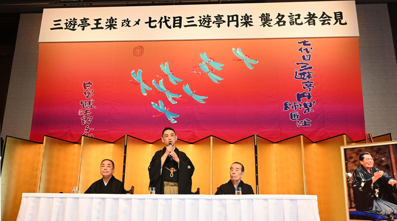 七代目三遊亭円楽襲名記者会見であいさつする三遊亭王楽。左は三遊亭好楽、右は林家木久扇（撮影・千葉一成）