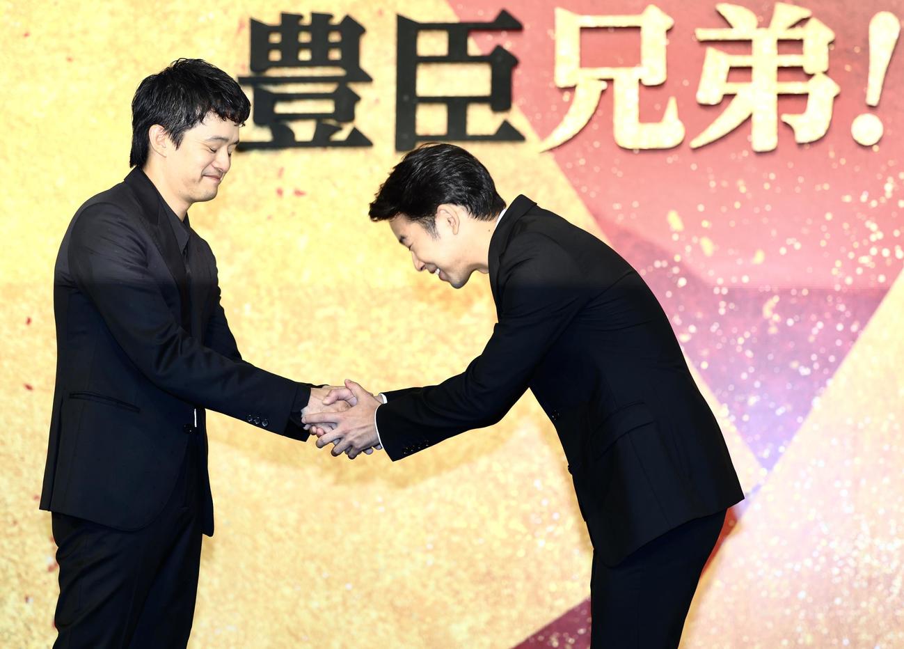 池松壮亮（左）と握手を交わす仲野太賀（撮影・河田真司）