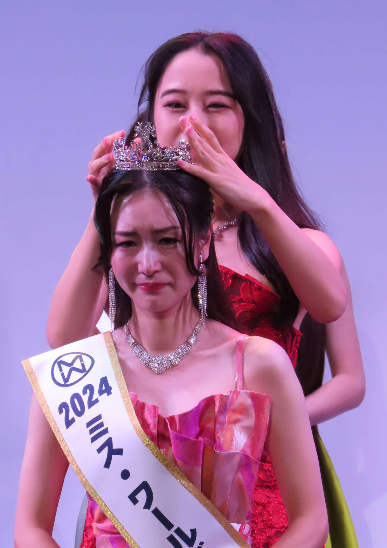 ミス・ワールド2024の日本代表に輝き、昨年度代表の根岸茉矢さんからティアラをもらう冨田キアナさん