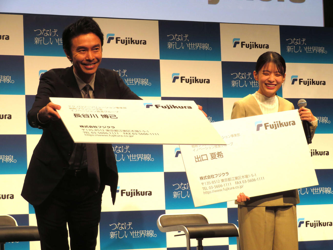 「つなげ、新しい世界線。フジクラ新CM発表会」に出席し、特大の名刺を使ってあいさつする長谷川博己と出口夏希
