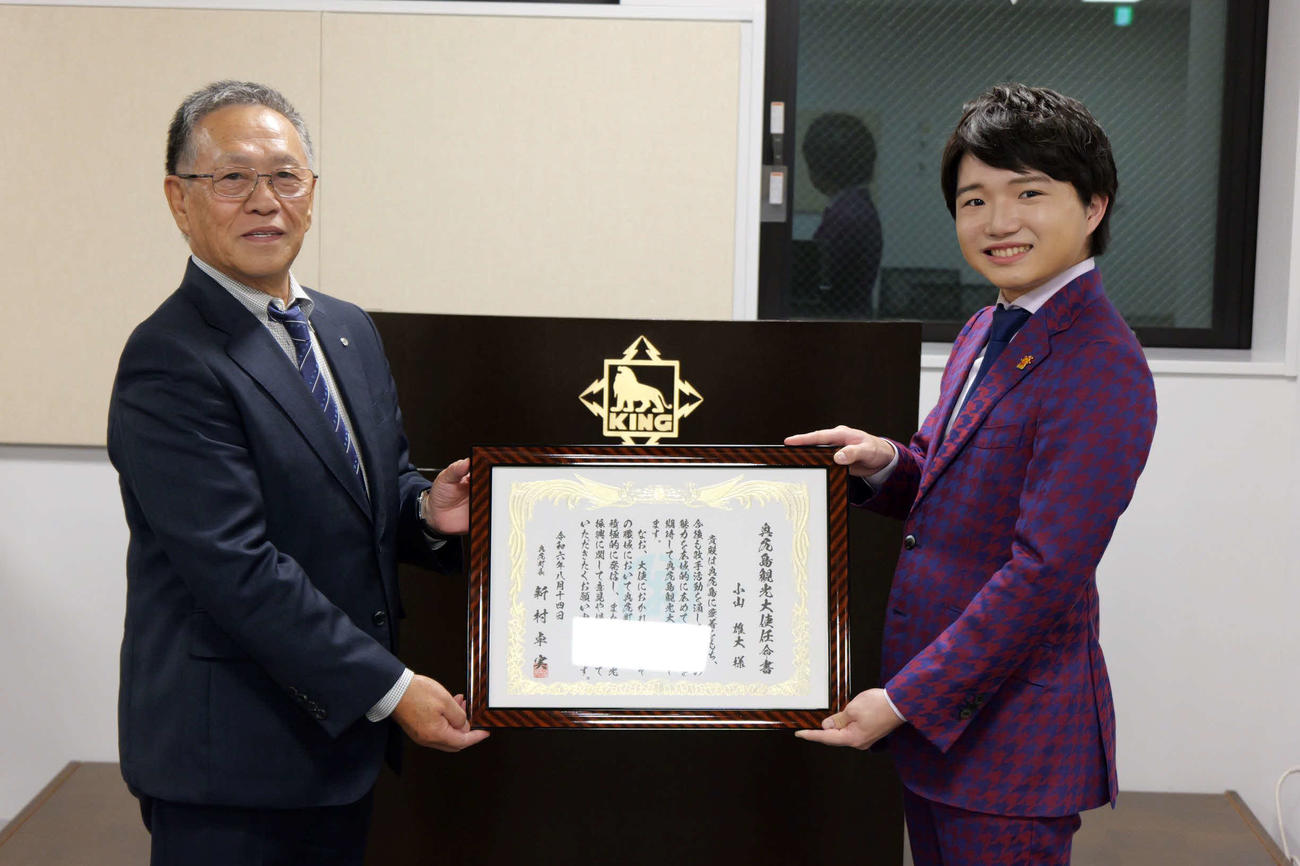 「奥尻島観光大使」の委嘱状を受け取った小山雄大（右）と奥尻町の新村卓実町長