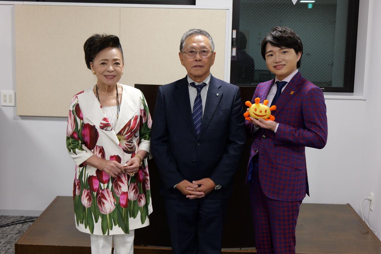 「奥尻島観光大使」の委嘱状を受け取った小山雄大（中央）。左は松前ひろ子、右は奥尻町の新村卓実町長