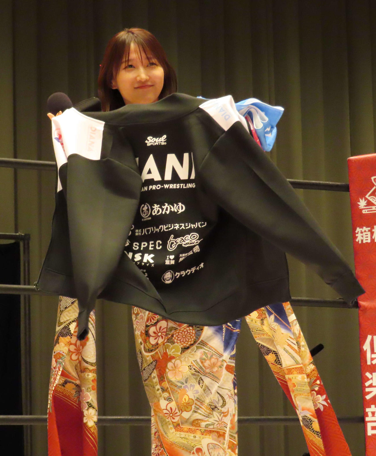 ワールド女子プロレス・ディアナのタイアップイベント「『十一人の女軍』バトルロイヤル」で、プレゼントされたディアナのジャージーを手に笑顔を見せる鞘師里保