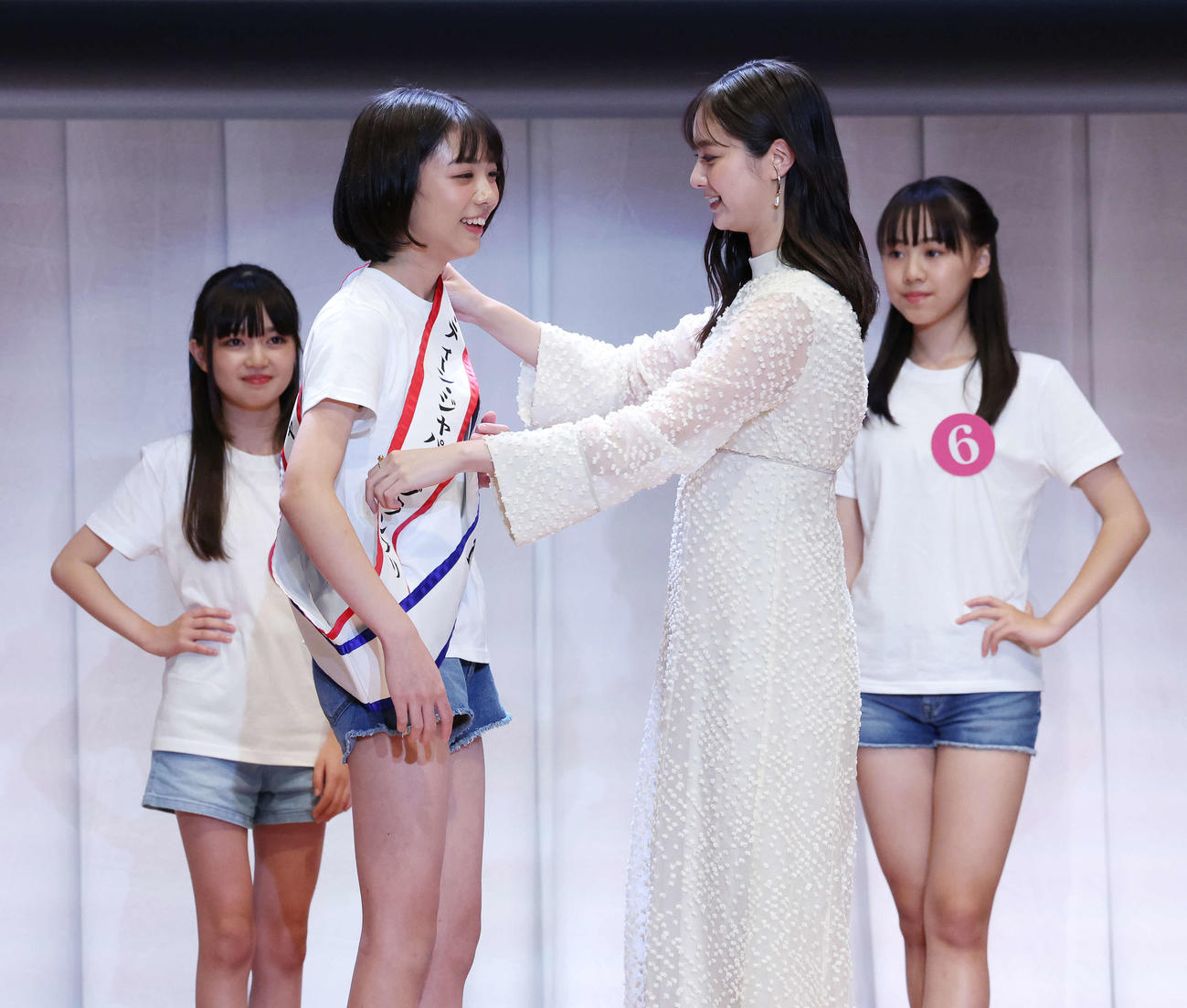 「2025ミス・ティーン・ジャパン」決勝大会でグランプリに輝いた増田有沙さん（左）は新川優愛にタスキを掛けてもらう（撮影・宮地輝）