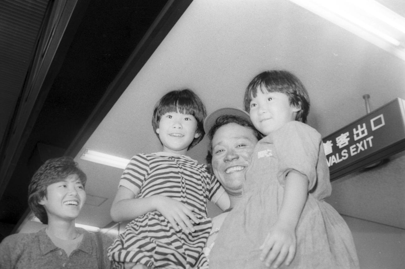 「植村直己物語」アラスカ、北極ロケから2カ月半ぶりに帰国、家族の出迎えを受け凍傷の残る顔をほころばす西田敏行。左から寿子夫人（33歳）、長女梨沙ちゃん（8歳）、次女沙耶歌ちゃん（5歳）（1985年5月）