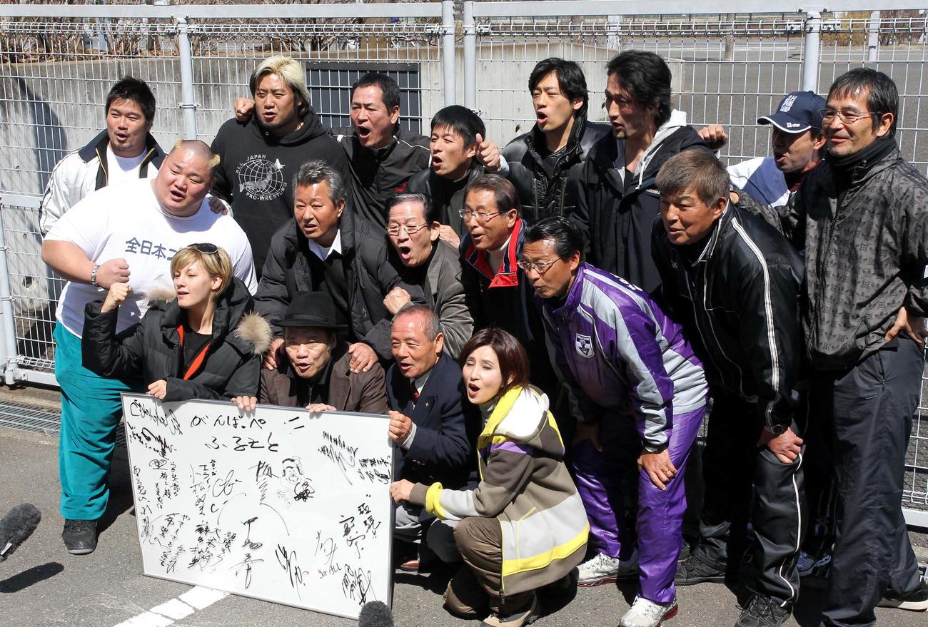 東日本大震災の被災者へ応援メッセージを書いた、前列左から梅宮アンナ、西田敏行さん、重量挙げ三宅義信氏、秋吉久美子、中列左から浜亮太、梅宮辰夫さん、小松政夫さん、高田繁氏、大八木弘明駒大駅伝部監督、山本功児さん、後列左からKAI、諏訪魔、中畑清氏、山田雅人、尾崎勇気（元関脇隆乃若）、大野均ラグビー元日本代表、篠塚和典氏、定岡正二氏＝2011年3月27日