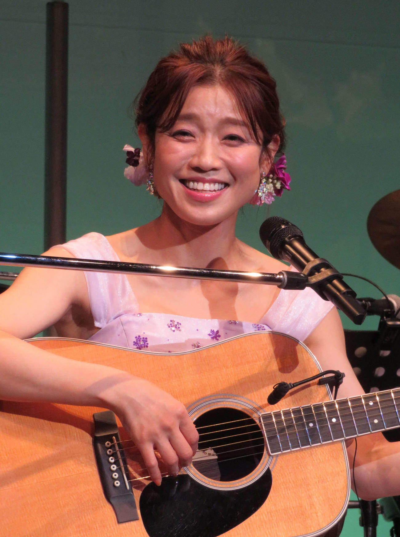 ギターの弾き語りで歌う川野夏美
