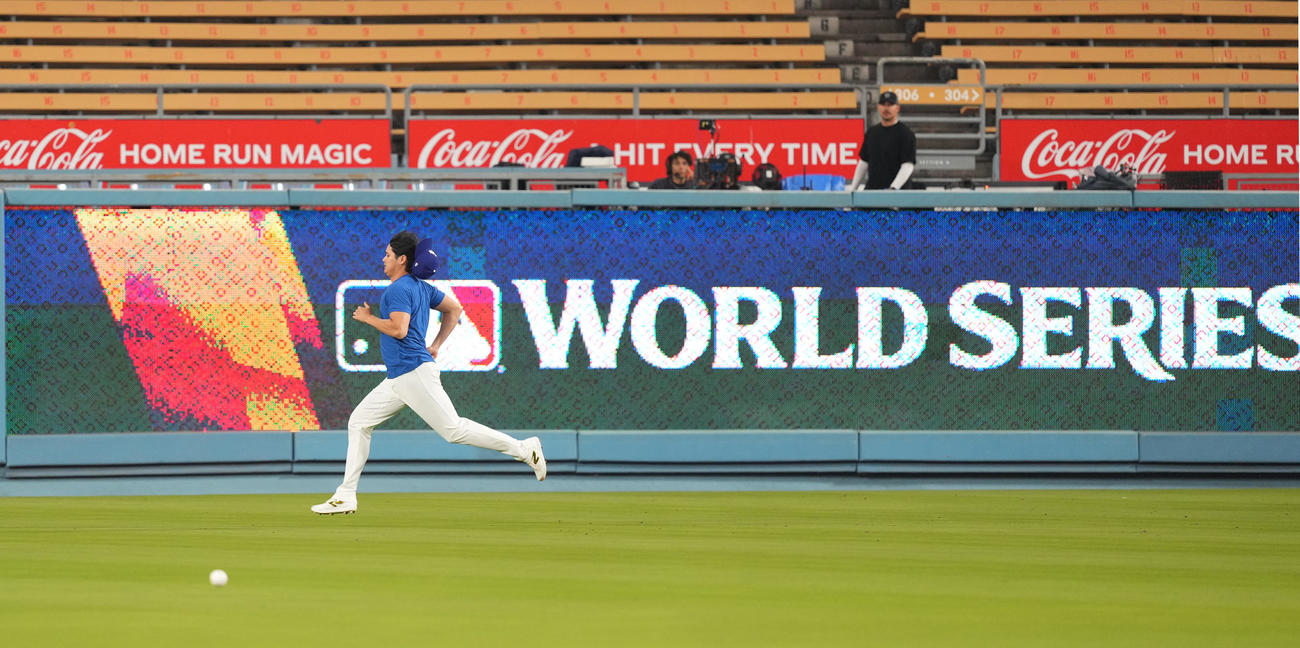 ワールドシリーズ前日、ワールドシリーズの文字を横目にダッシュをするドジャース大谷は、勢い余って帽子を飛ばす（撮影・菅敏）