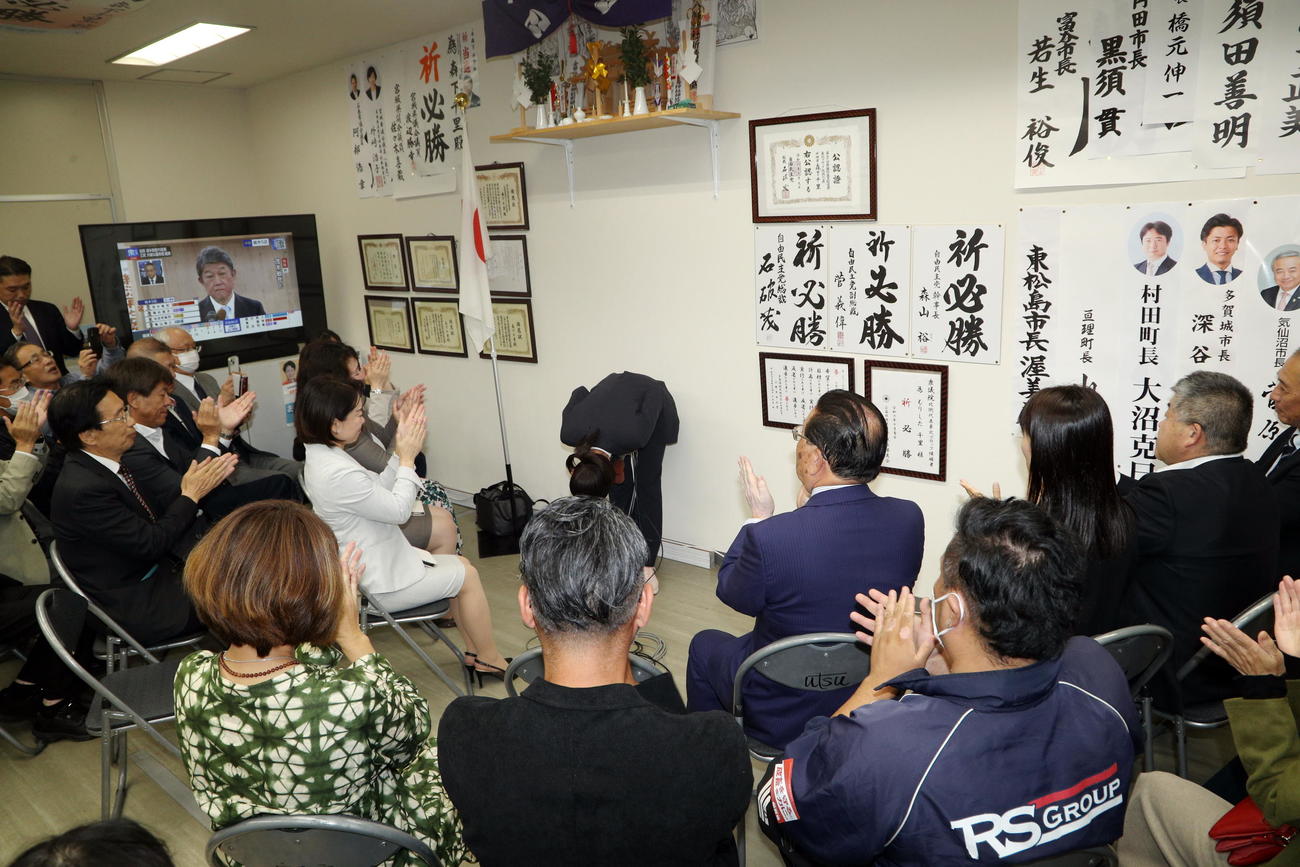 初の当選確実の一報を受け、深々と支援者に頭を下げる自民党の森下千里氏（撮影・木村有優）