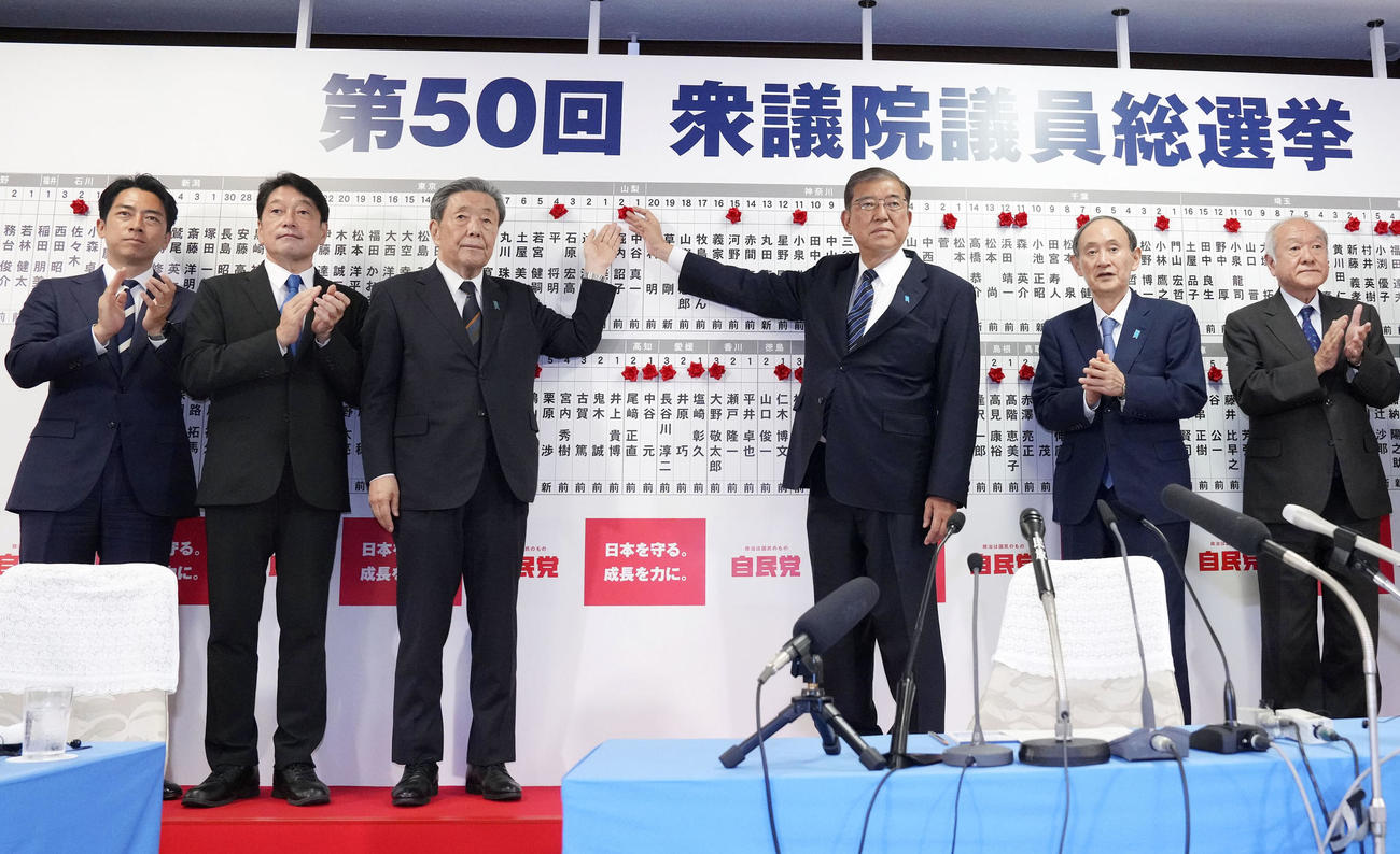 当確者の名前にバラを付ける自民党総裁の石破首相（中央右）ら（共同）