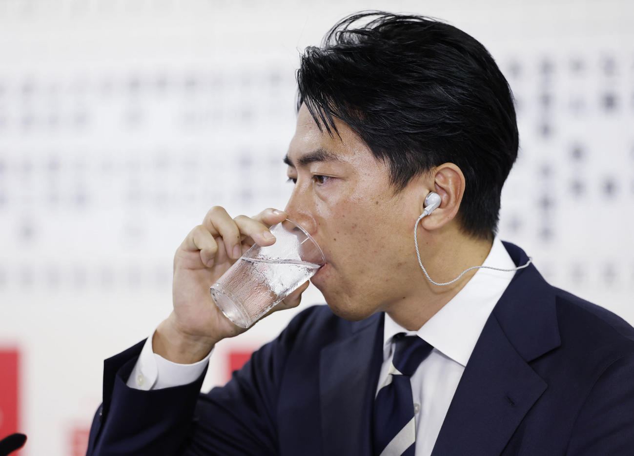 メディアのインタビューの合間に水を飲む自民党の小泉選対委員長（共同）