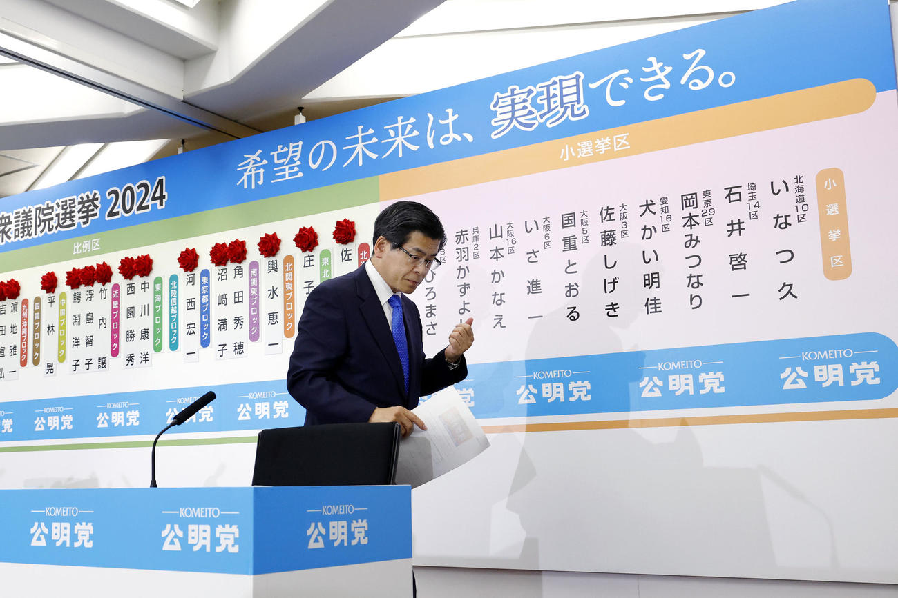 メディアの取材を終え、引き揚げる公明党の石井代表（共同）