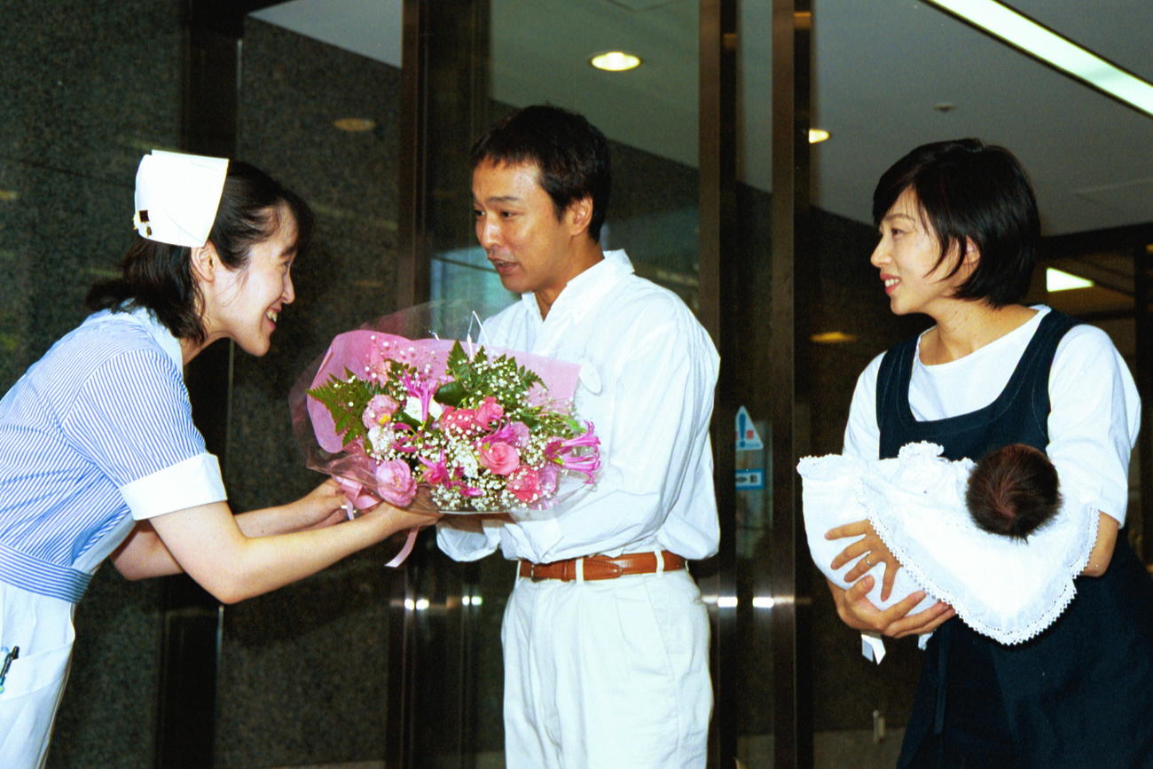 01年7月、退院で看護師から花束を受け取る太川陽介、藤吉久美子夫妻