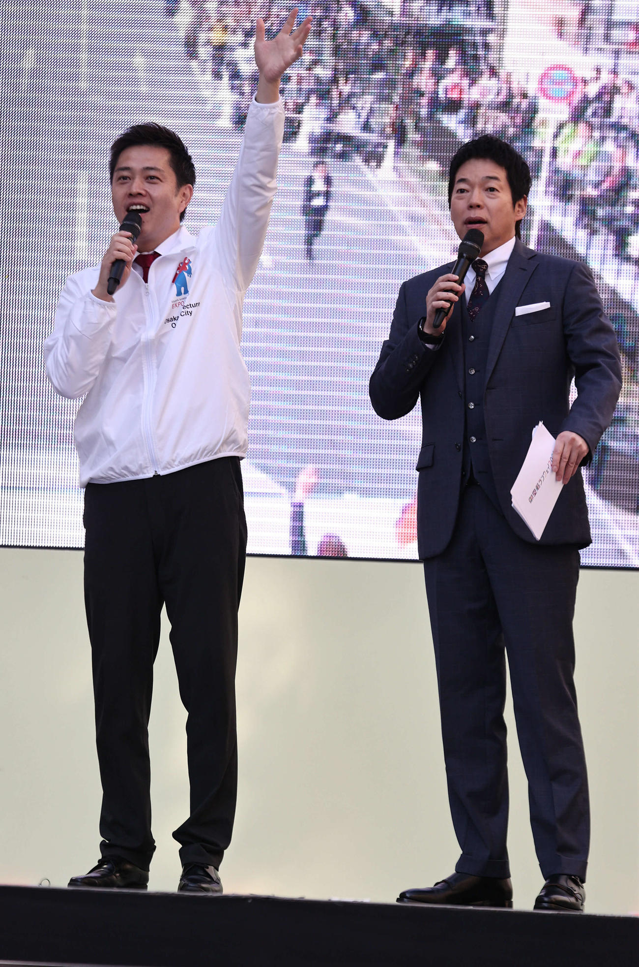 御堂筋ランウェイの開会宣言で吉村洋文大阪府知事は観客に手を振る。右は今田耕司（撮影・西尾就之）
