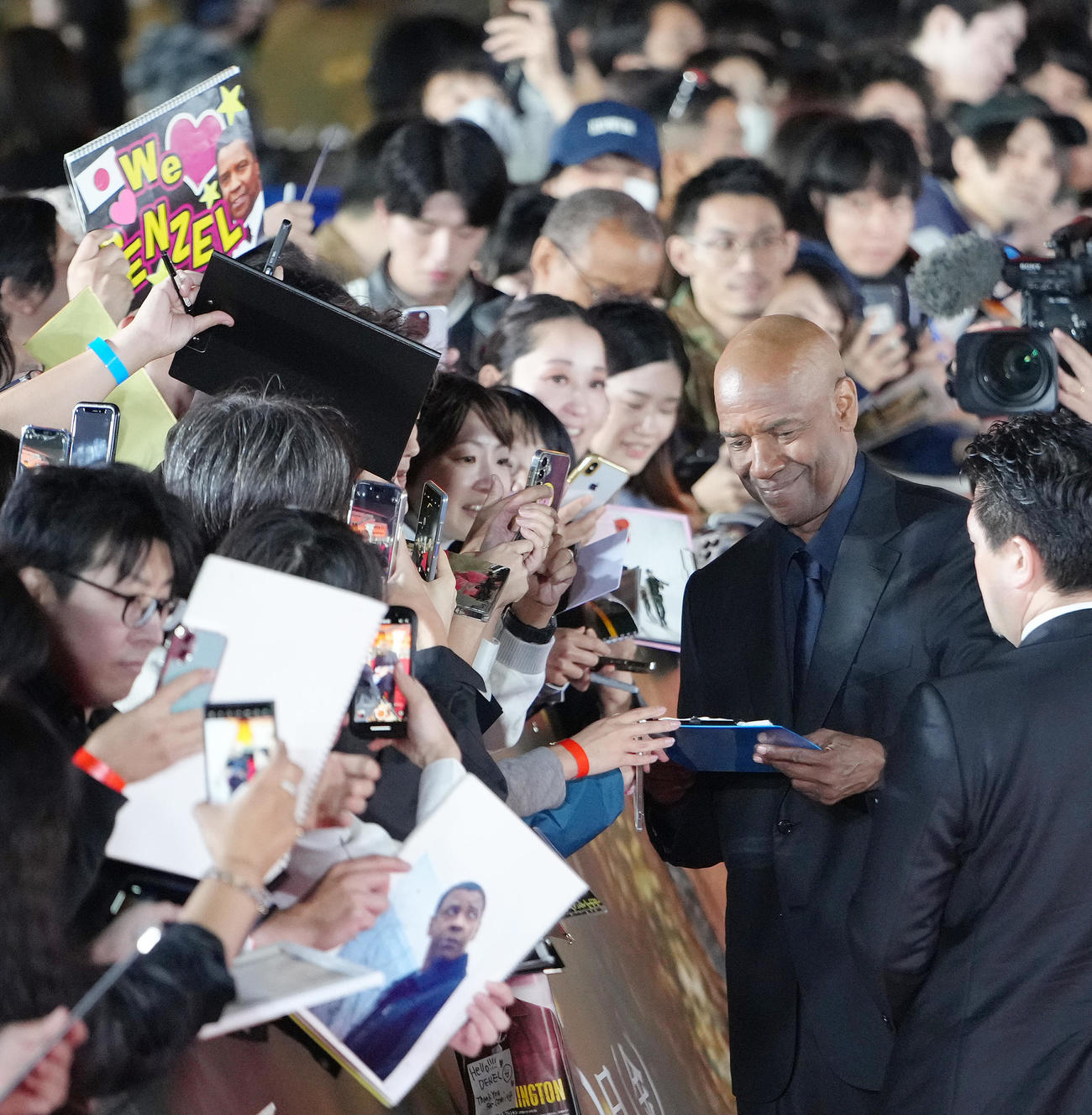 レッドカーペットに登場し、ファンのサインに応えるデンゼル・ワシントン（右）（撮影・足立雅史）