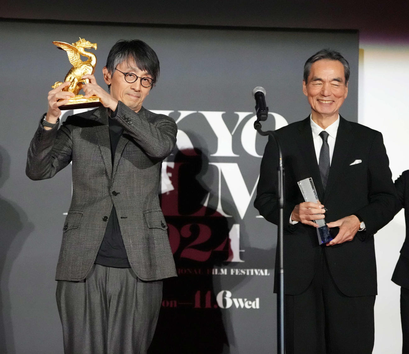 第37回東京国際映画祭「クロージングセレモニー」で映画「敵」がコンペティション部門の東京グランプリ／東京都知事賞を受賞しトロフィーを掲げる吉田大八監督。右は最優秀男優賞の長塚京三（撮影・小沢裕）