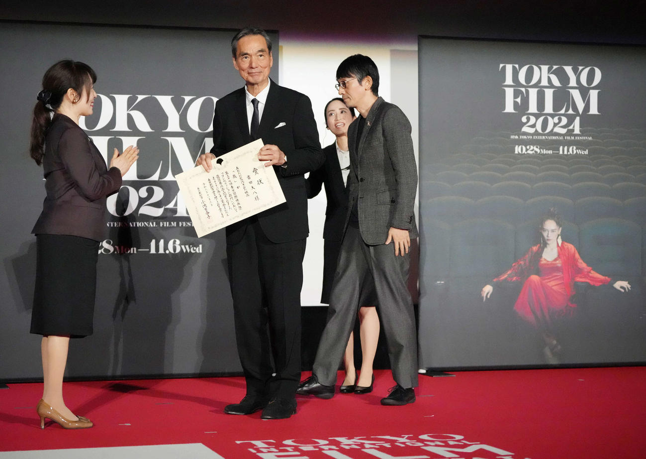 第37回東京国際映画祭「クロージングセレモニー」で映画「敵」がコンペティション部門の東京グランプリ／東京都知事賞を受賞し表彰状を受け取る長塚京三（中央）。右は吉田大八監督（撮影・小沢裕）
