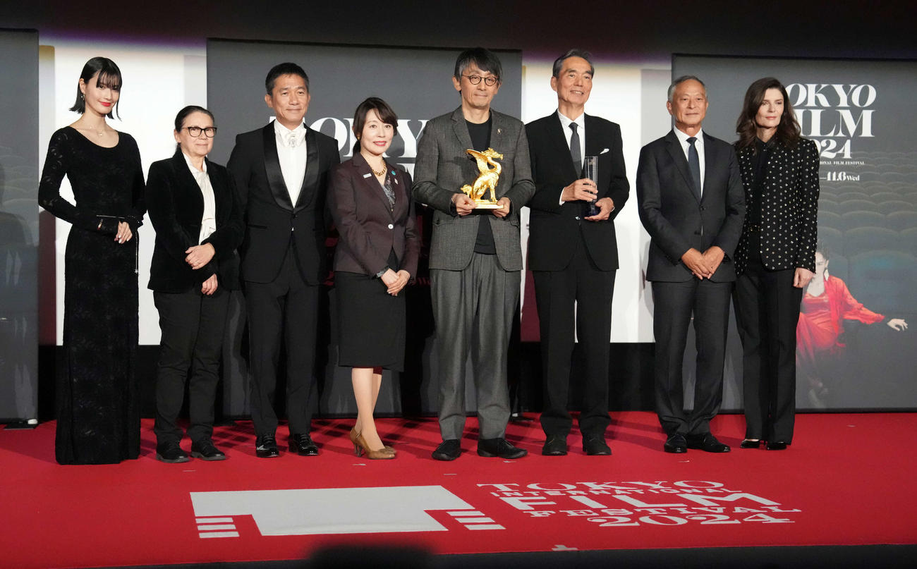 第37回東京国際映画祭「クロージングセレモニー」で映画「敵」がコンペティション部門の東京グランプリ／東京都知事賞を受賞しトロフィーを手に審査委員と記念撮影に臨む（中央左から吉田大八監督、最優秀男優賞の長塚京三。左端は橋本愛（撮影・小沢裕）