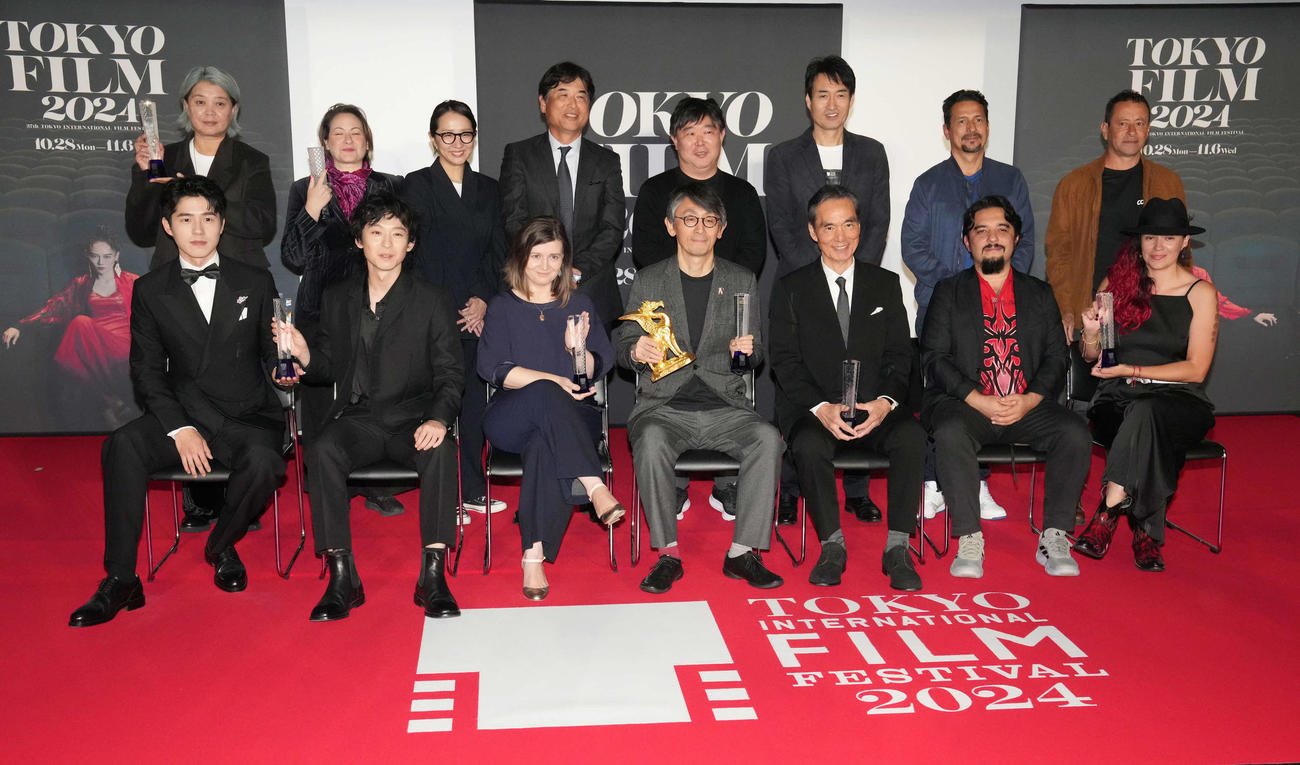 第37回東京国際映画祭「クロージングセレモニー」で映画「敵」がコンペティション部門の東京グランプリ／東京都知事賞を受賞しトロフィーを手に受賞者らと記念撮影に臨む吉田大八監督（前列中央）。同右は最優秀男優賞の長塚京三（撮影・小沢裕）