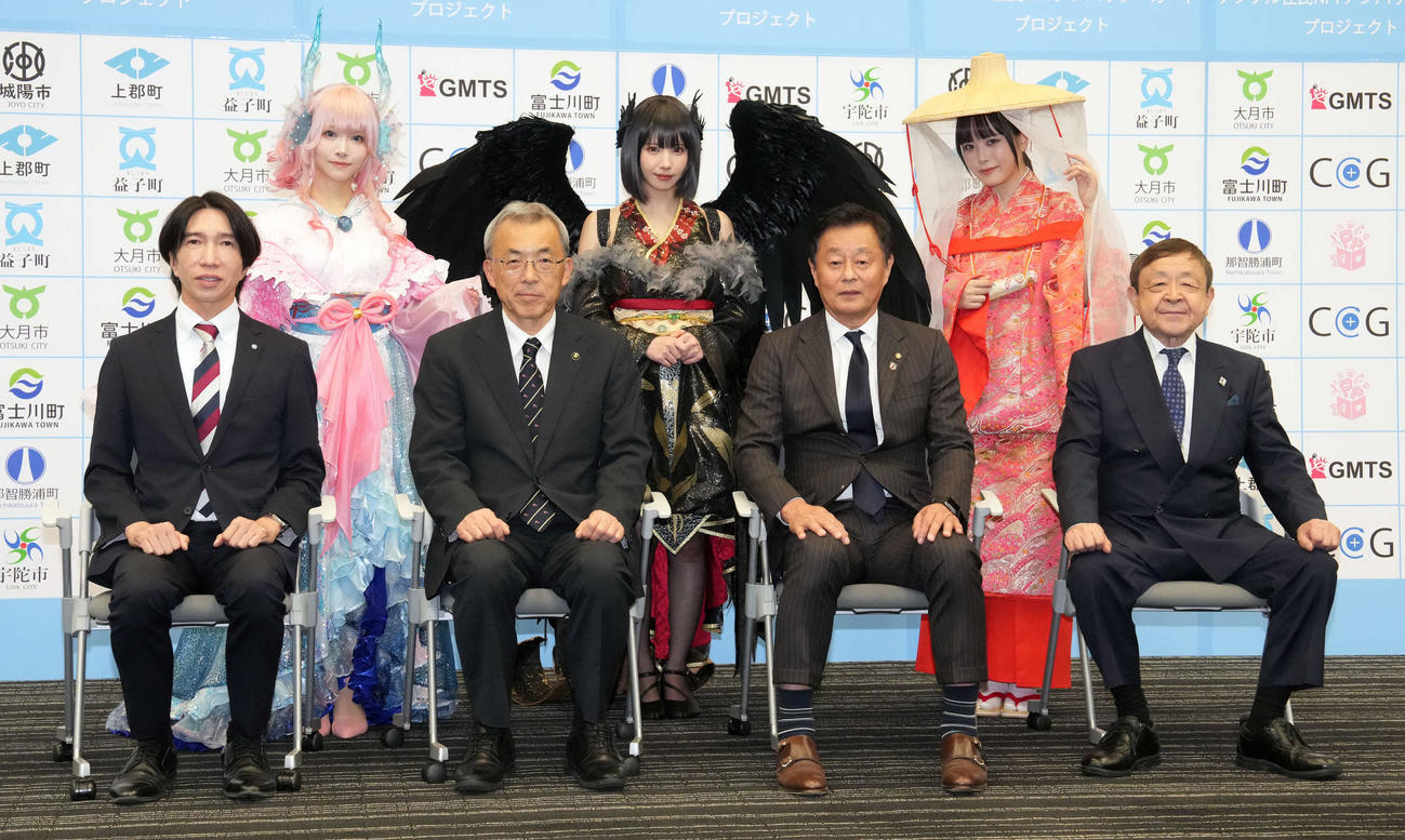 「デジタル住民NFTアンバサダーカード」プロジェクト記者発表会のフォトセッションに臨む、前列左から兵庫県上郡町の梅田町長、奈良県宇陀市の金剛市長、和歌山県那智勝浦町の堀町長、公民連携推進機構の池田専務理事、後列左から人気コスプレイヤーのえい梨、えなこ、東雲うみ（撮影・小沢裕）