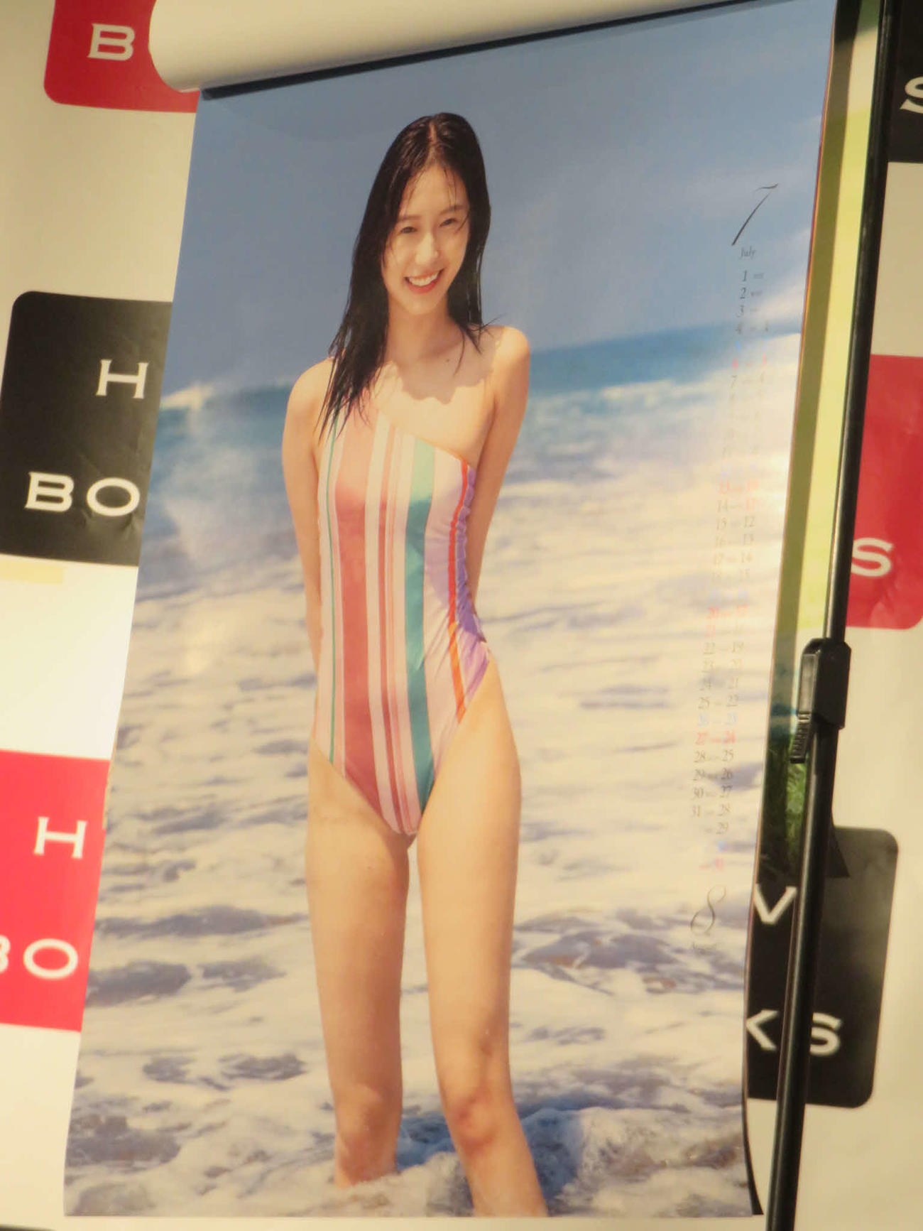 「志田音々　2025カレンダー」でレインボーカラーのストライプの水着姿を披露する志田音々