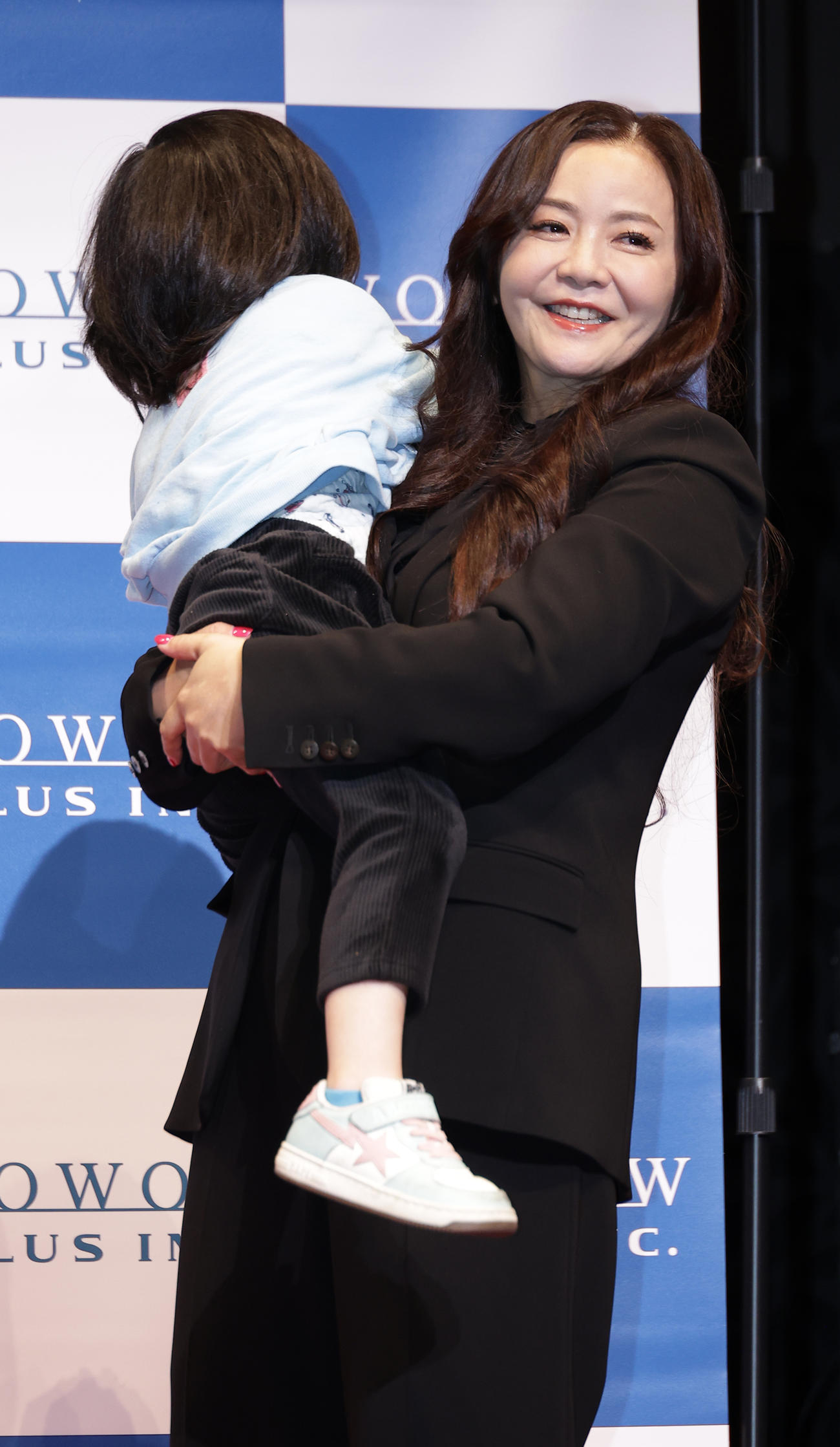 会見に参加した息子（左）を抱き上げ退場する華原朋美（撮影・中島郁夫）