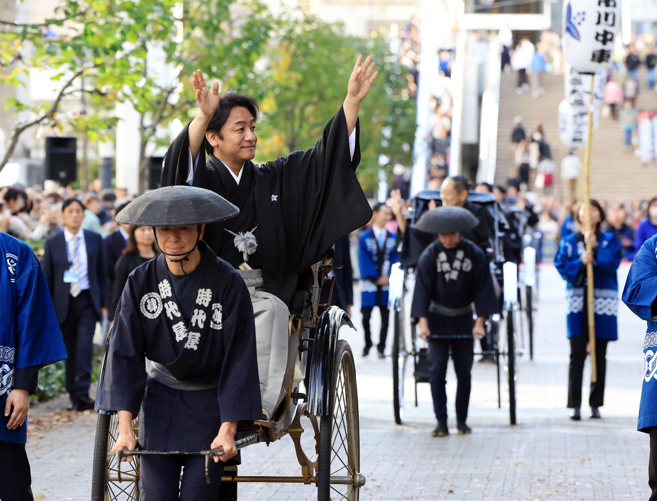 「立川立飛歌舞伎特別公演　お練り」で、人力車からファンに手を振る片岡愛之助。右後方には市川中車（撮影・浅見桂子）