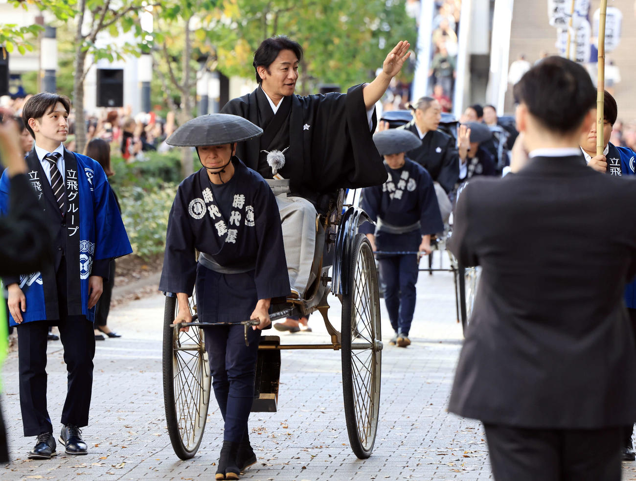 「立川立飛歌舞伎特別公演　お練り」で、人力車からファンに手を振る片岡愛之助。右後方には市川中車（撮影・浅見桂子）
