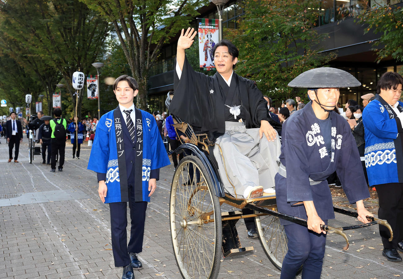 「立川立飛歌舞伎特別公演　お練り」で、人力車からファンに手を振る片岡愛之助。左後方には市川中車（撮影・浅見桂子）