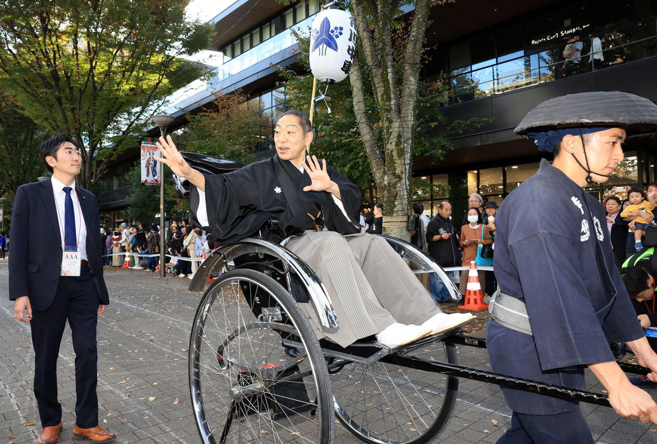 「立川立飛歌舞伎特別公演　お練り」で、人力車からファンに手を振る市川中車（撮影・浅見桂子）